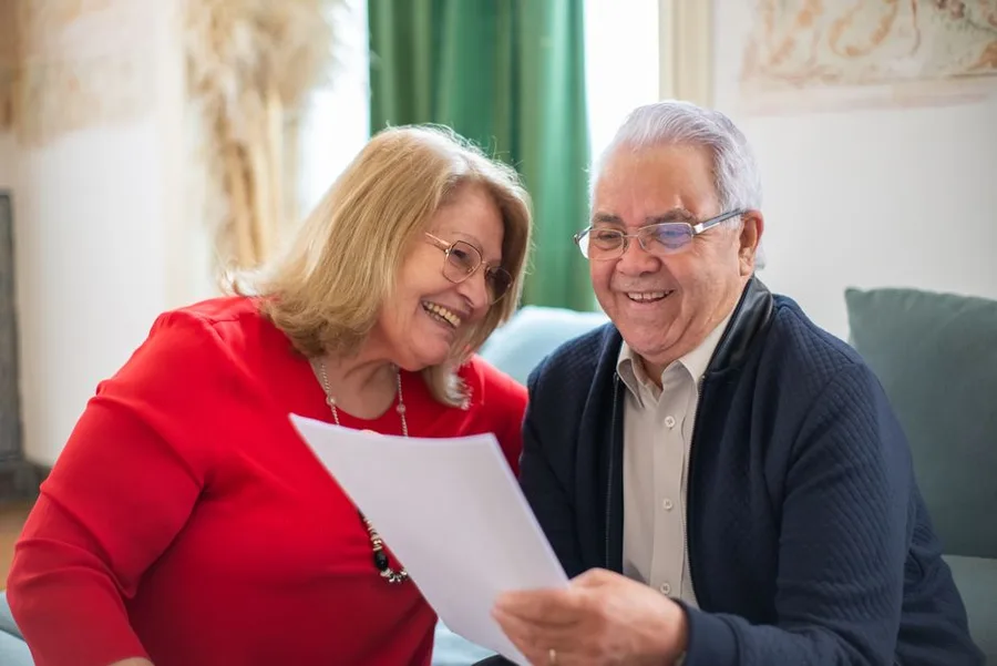 Couple happily weighing dental implants versus dentures options
